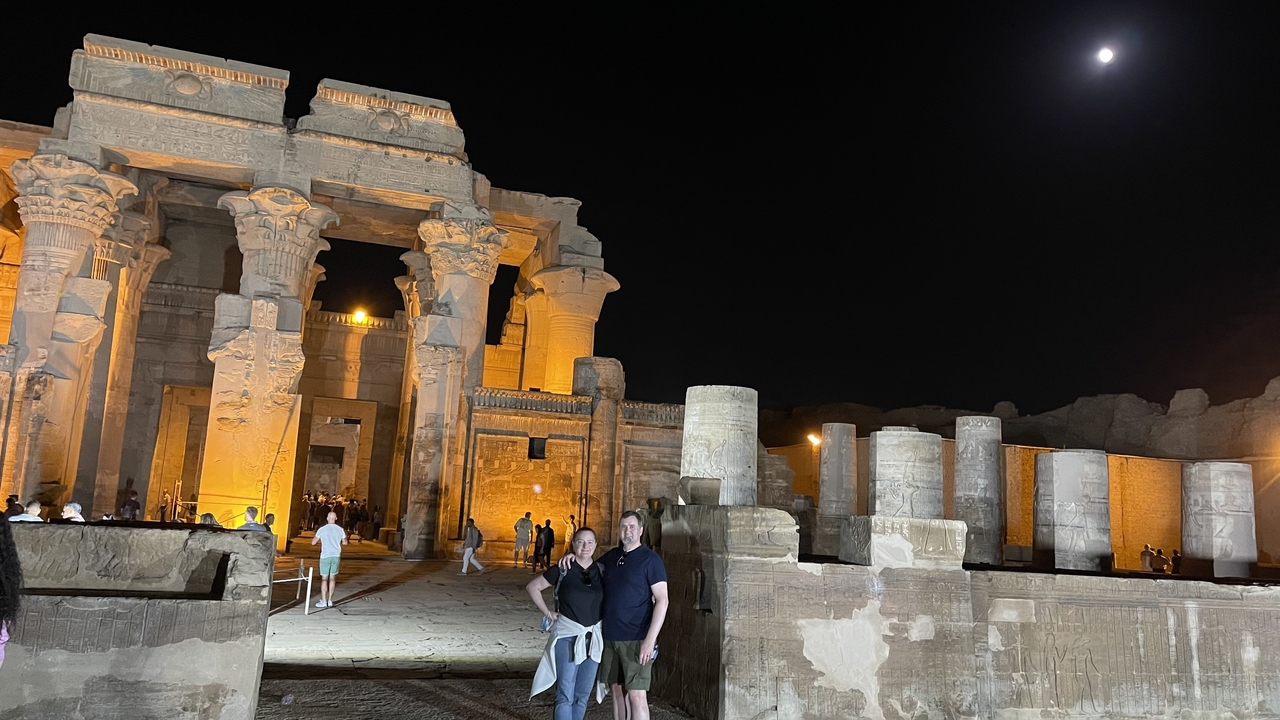 Couple posant devant des ruines de temple illuminées