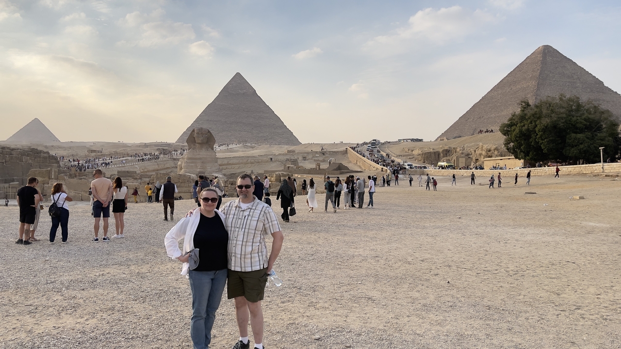 Des touristes posant avec les pyramides et le Sphinx.