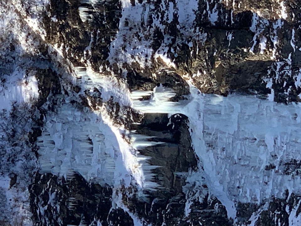 Face de falaise glacée avec glaciers visibles.