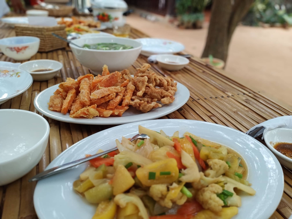 Assiettes de nourriture sur une table en bambou, présentant différents plats.