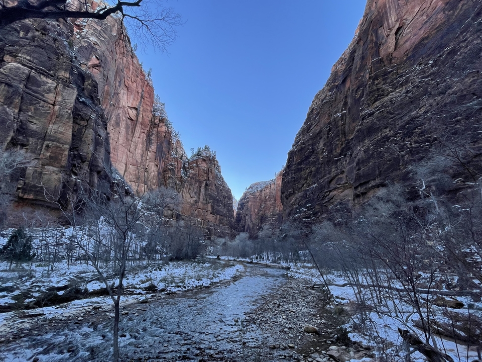 Canyon montagneux avec de la neige et un cours d'eau limpide.
