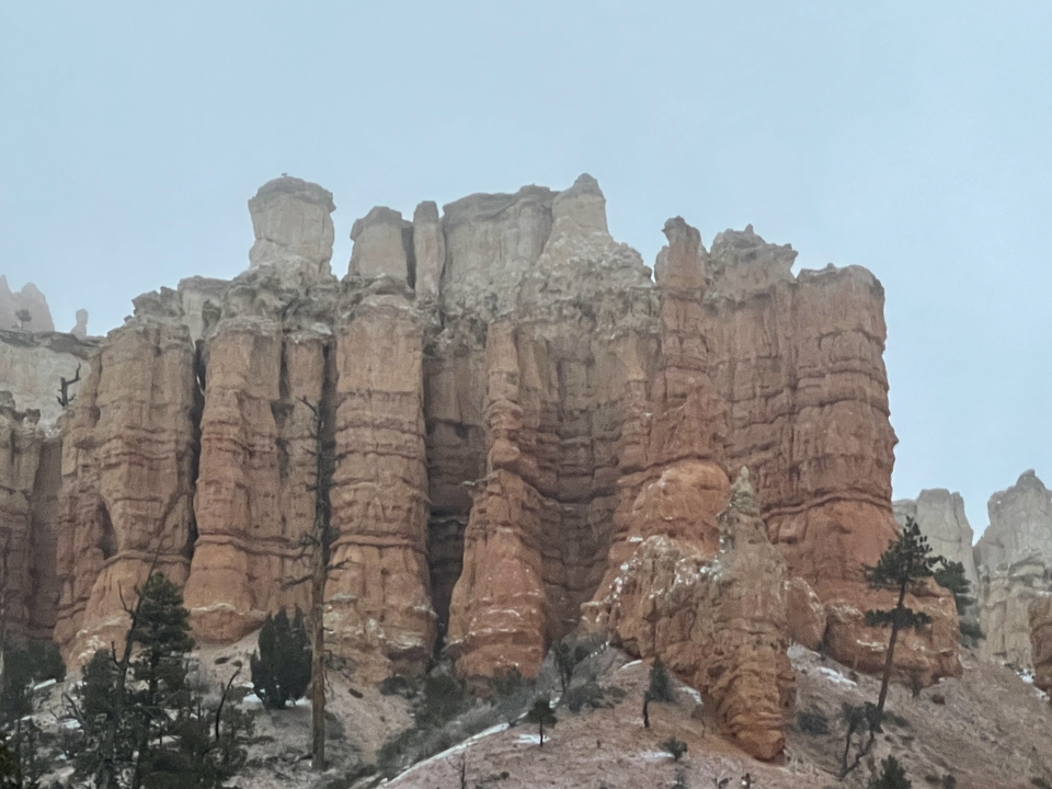 Des formations rocheuses rouges s'élevant majestueusement contre un ciel nuageux.