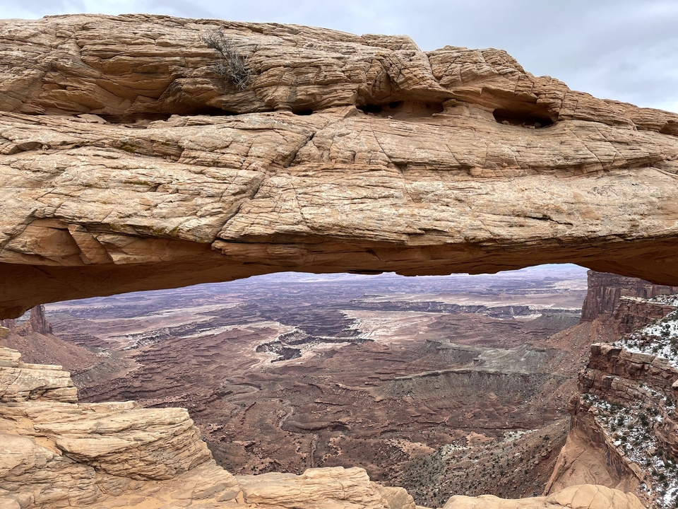 Vue panoramique à travers une arche naturelle dans le canyon.