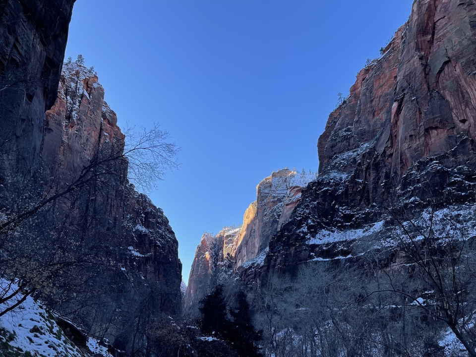 Canyon with snow along the cliffs and a clear blue sky.