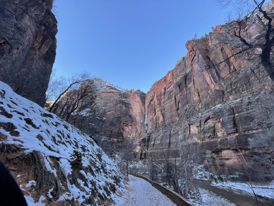 Paysage d'hiver avec des rochers enneigés et un ciel dégagé.
