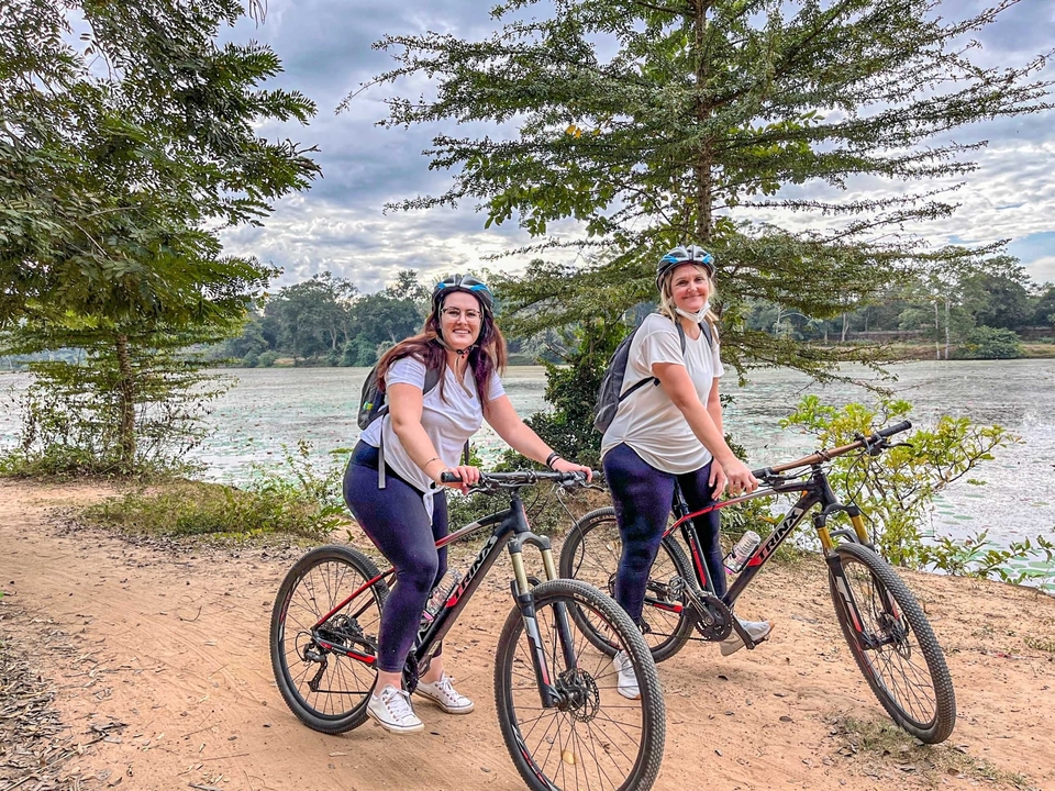 Deux femmes faisant du vélo le long d'une rivière.