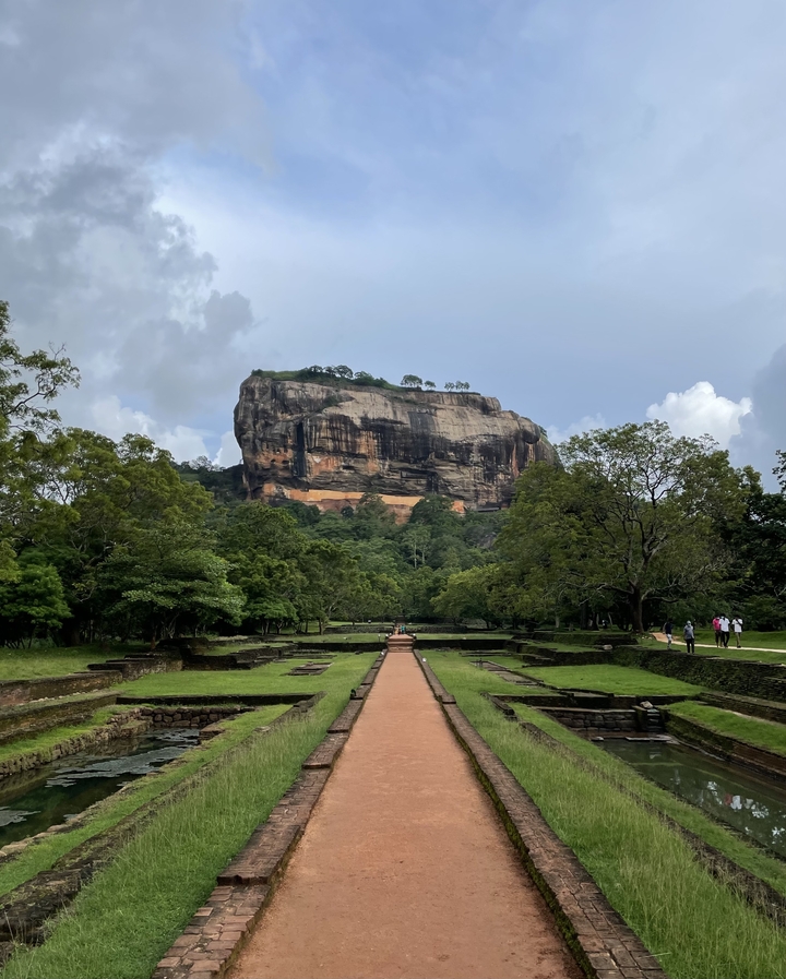 Grande formation rocheuse avec des personnes marchant à proximité