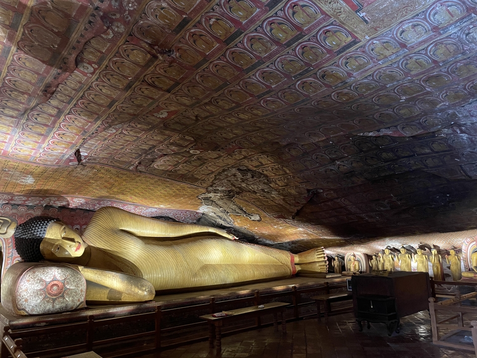 Statue dorée de Bouddha couché dans un temple troglodyte