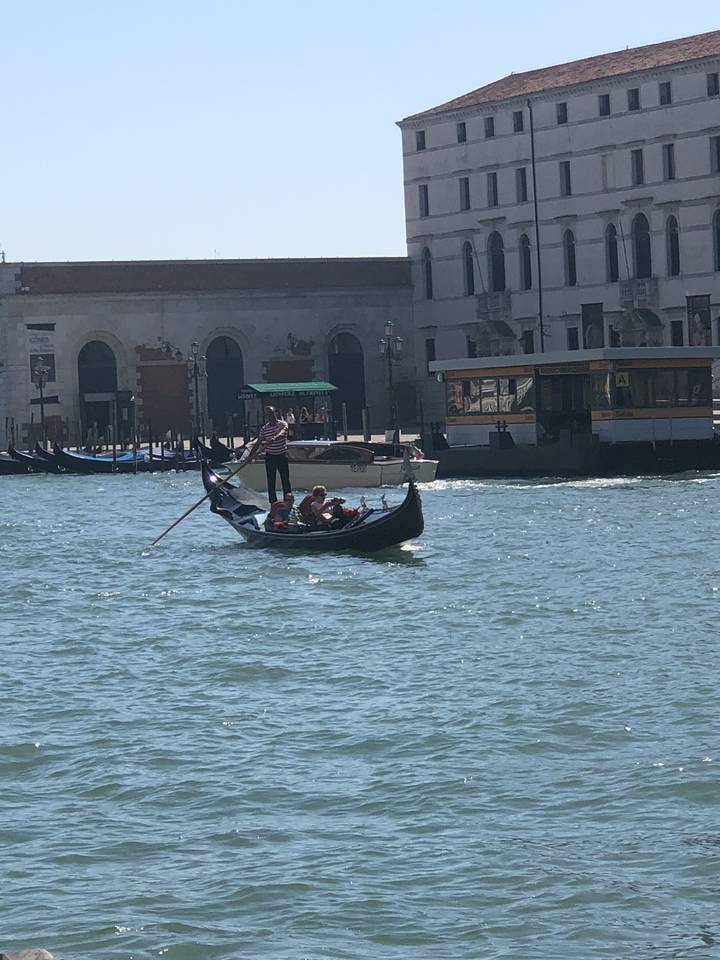 Gondole avec des touristes sur un canal vénitien.