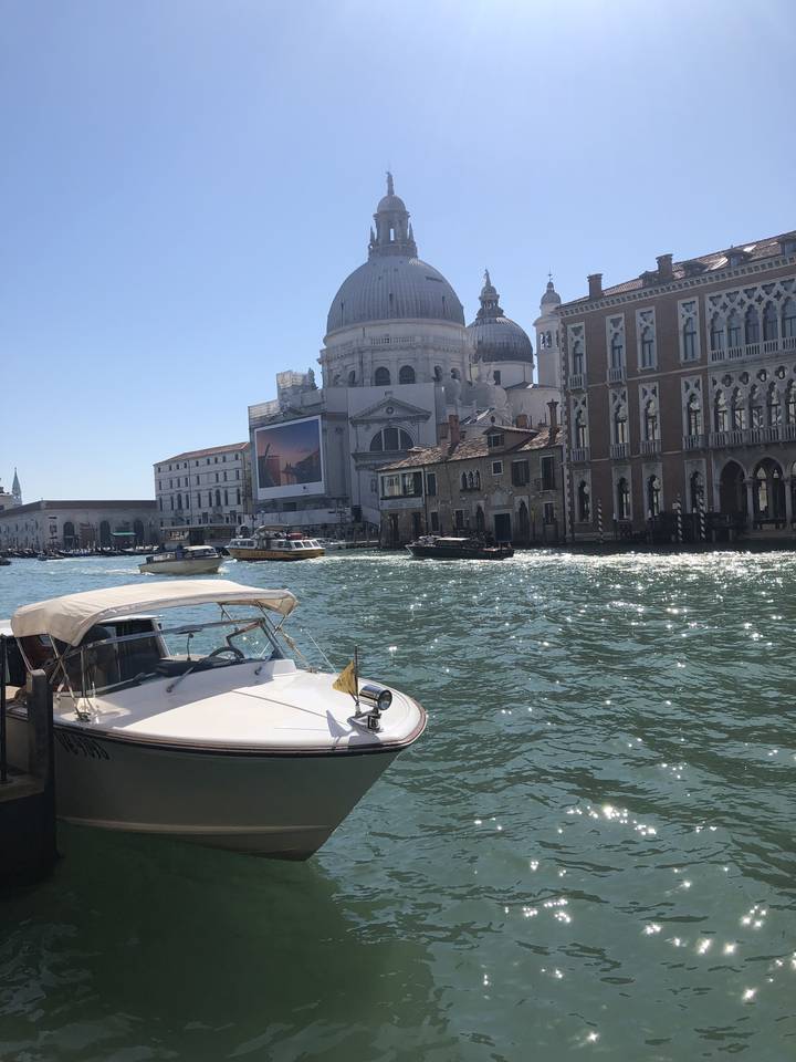 Bateau dans un canal vénitien avec des bâtiments historiques.