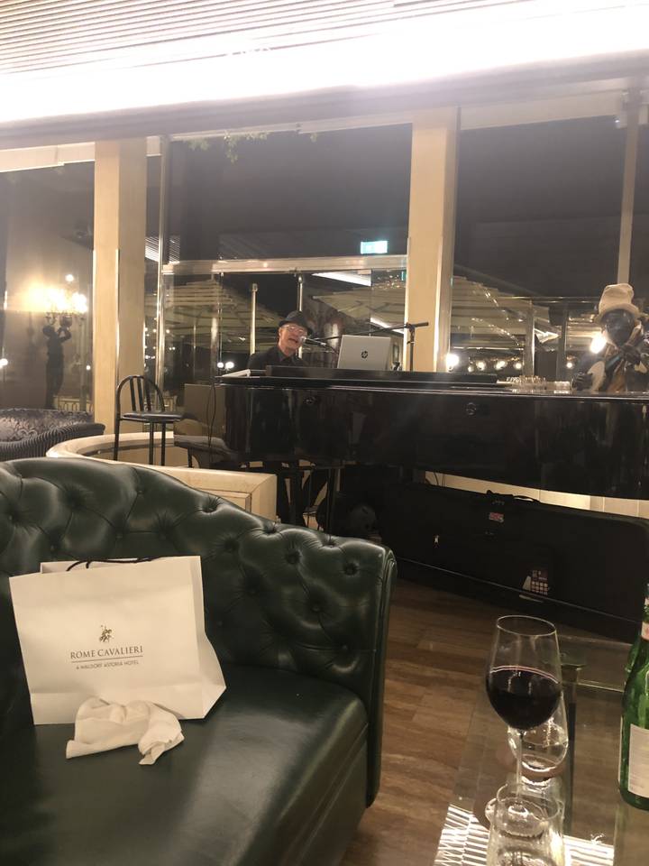 Salon d'hôtel avec un pianiste qui joue de la musique.