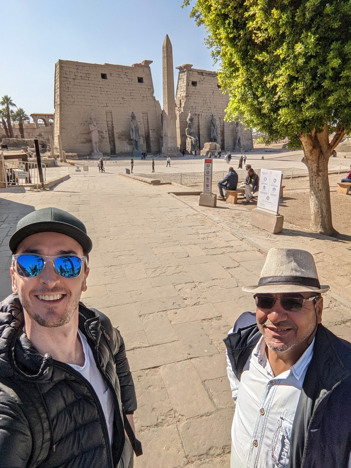 Selfie de deux personnes devant un temple égyptien antique.
