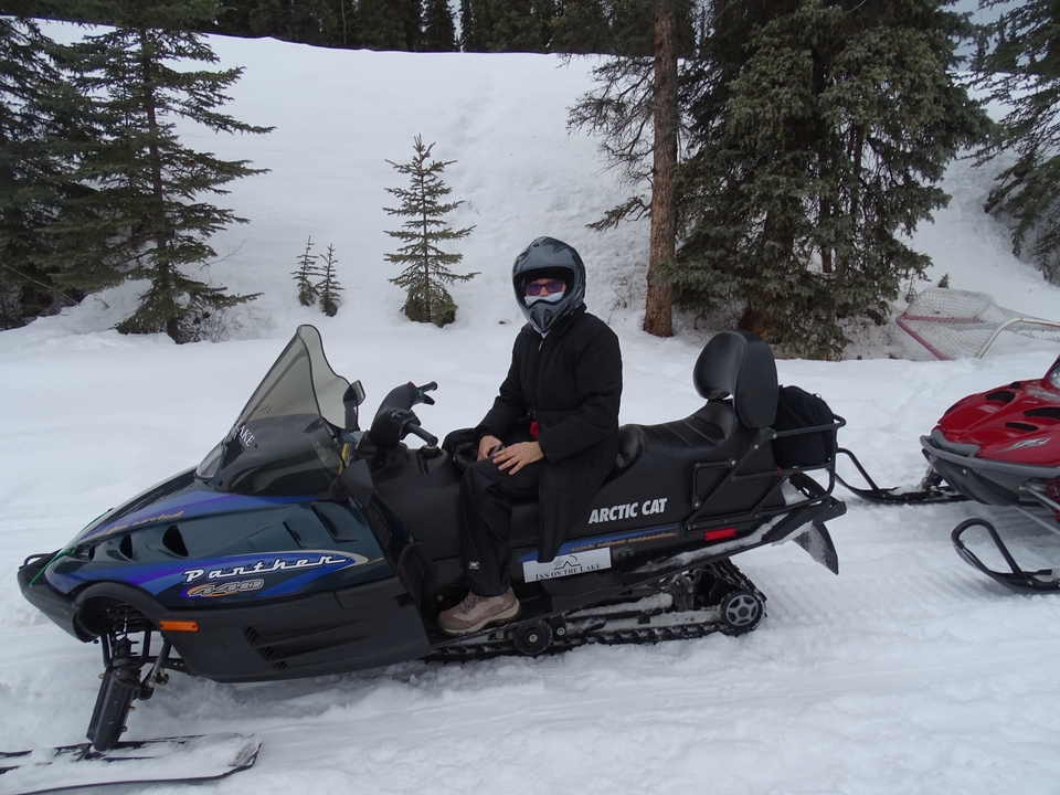 Une personne sur une motoneige dans la neige.