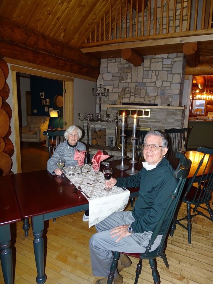 Deux personnes dînant près d'une cheminée en pierre.