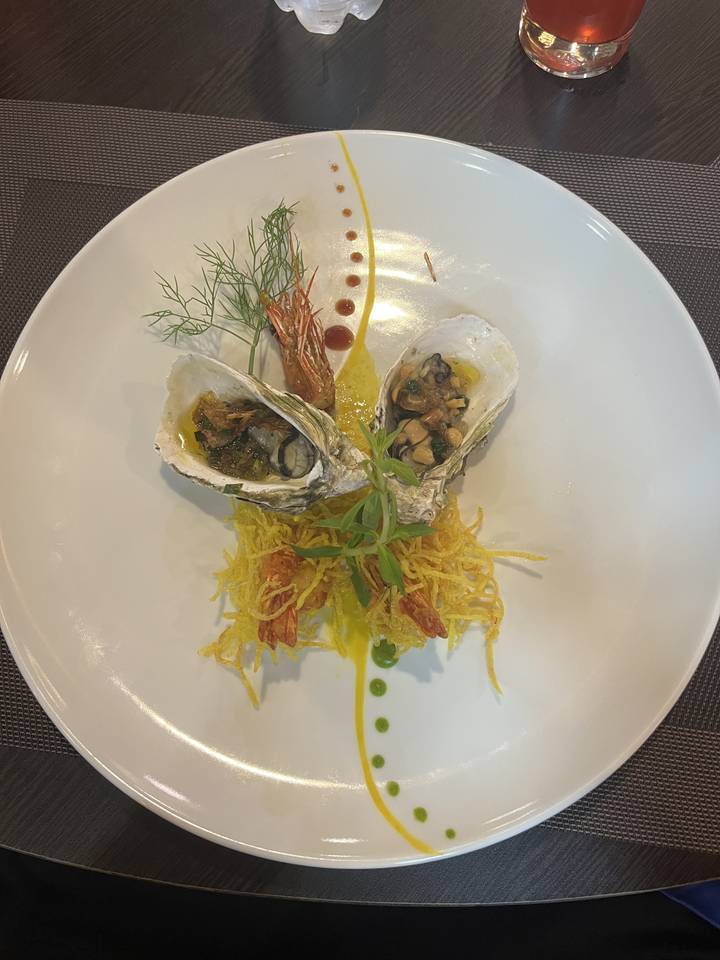 Plat de fruits de mer dressé avec des garnitures colorées disposées artistiquement.