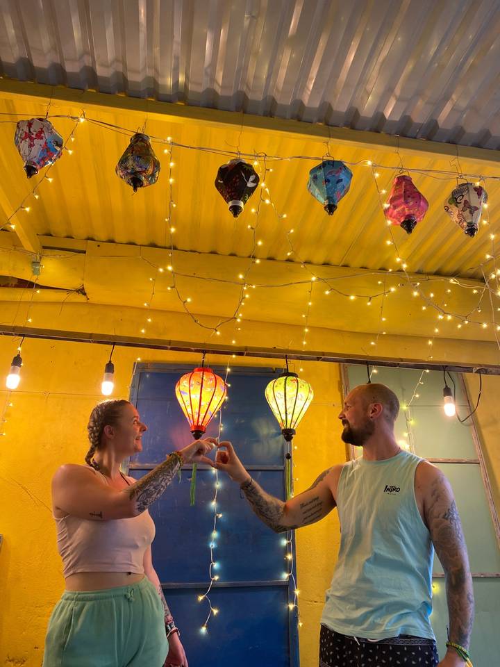 Couple à l'intérieur d'un espace mural coloré avec des lanternes.
