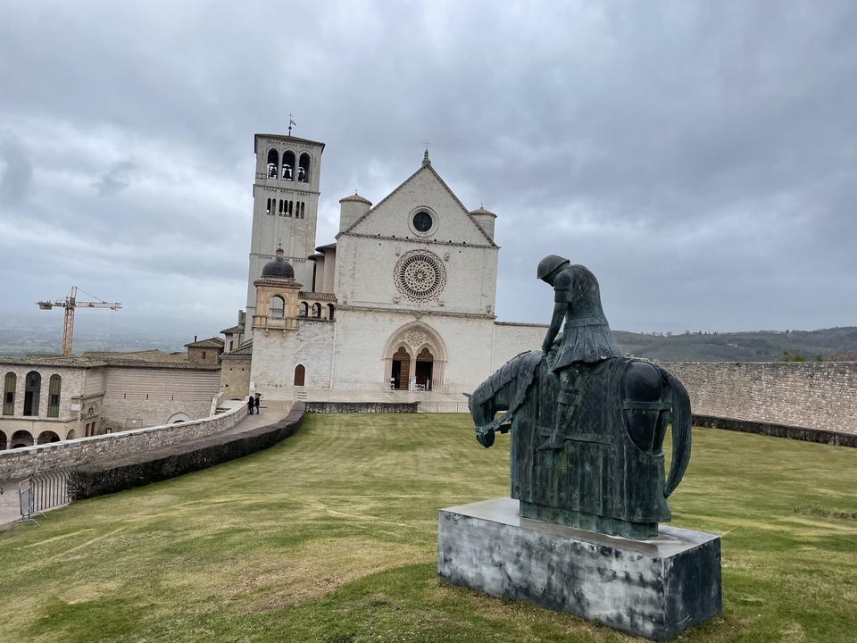 Une église avec une statue d'un chevalier à cheval au premier plan.