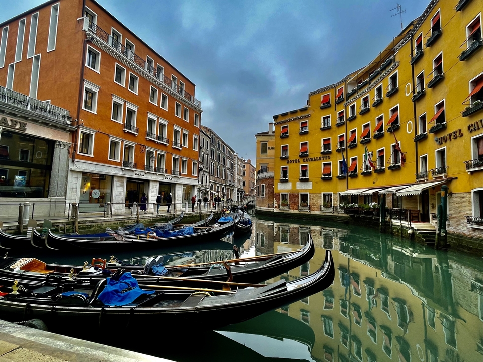Des gondoles sur un canal avec des bâtiments colorés.