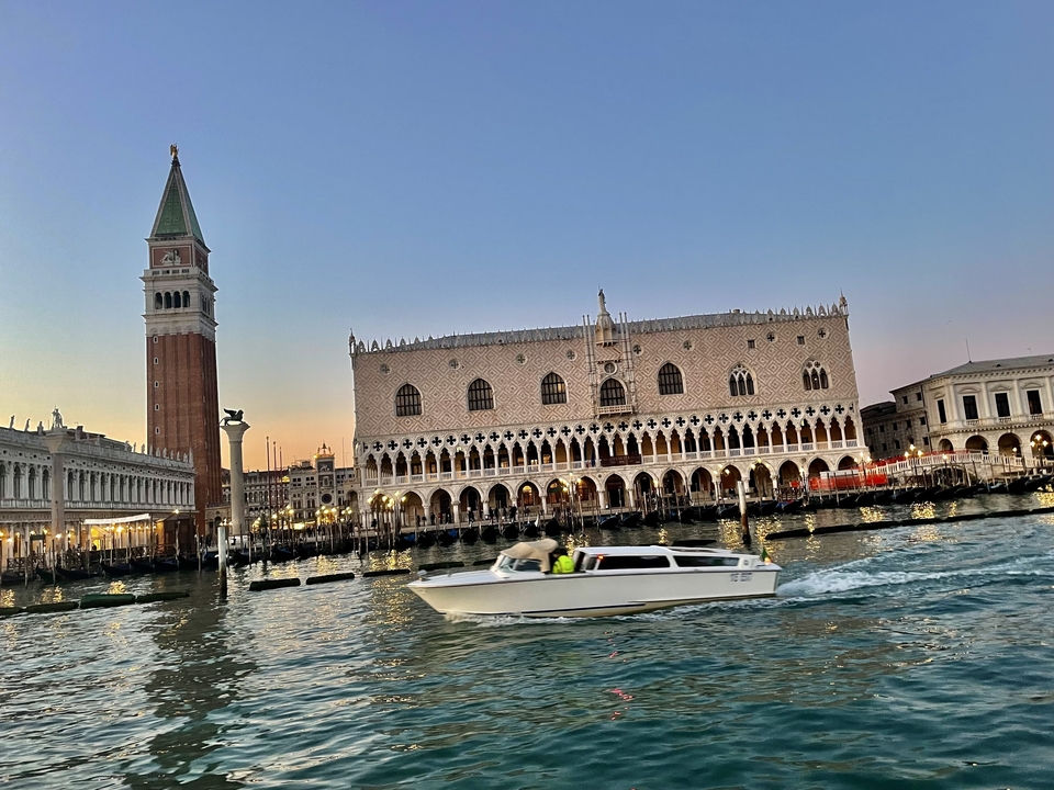 Un bateau filant devant l'architecture gothique vénitienne.
