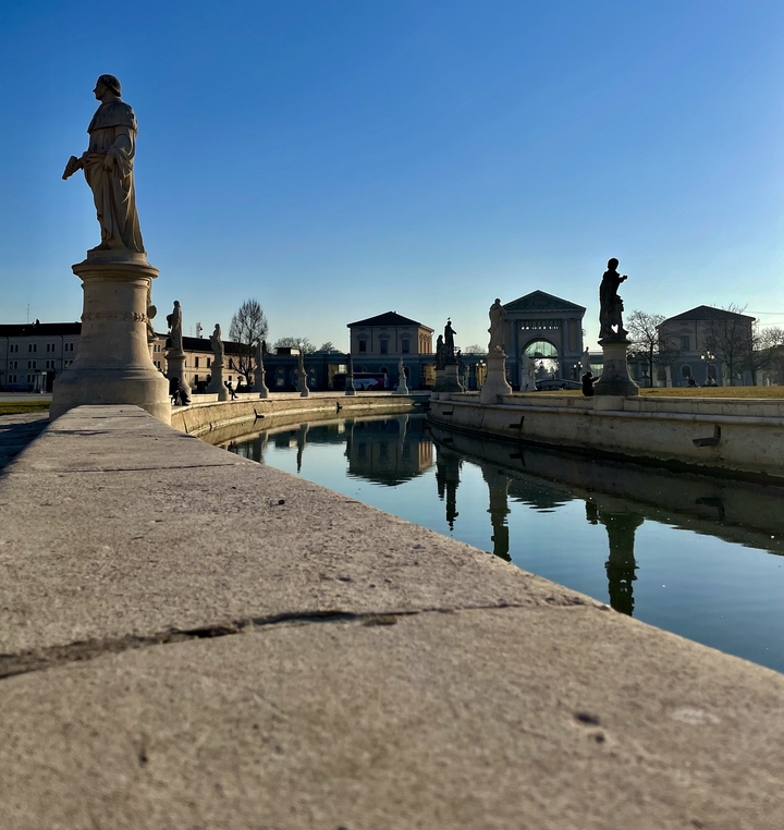 Un canal avec des statues qui bordent ses côtés.