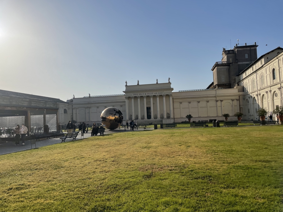 Une cour de musée avec une sculpture sphérique.