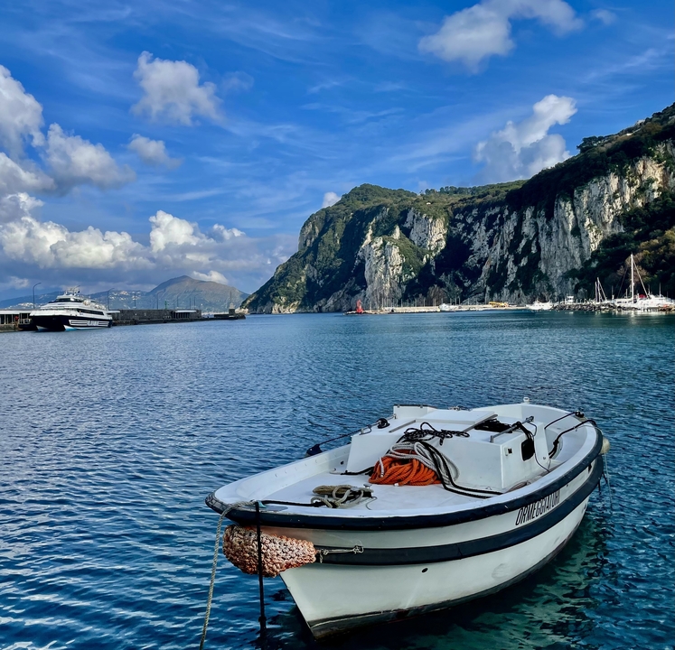 Bateaux amarrés dans un port pittoresque avec des falaises.