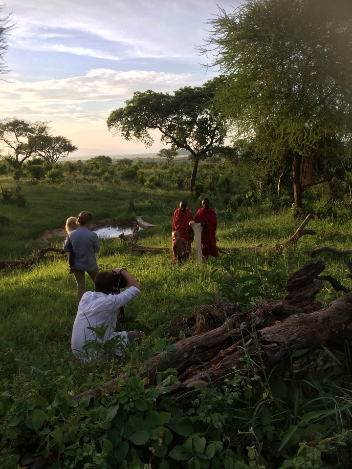 Des photographes prenant des photos de personnes Maasaï dans un paysage luxuriant.