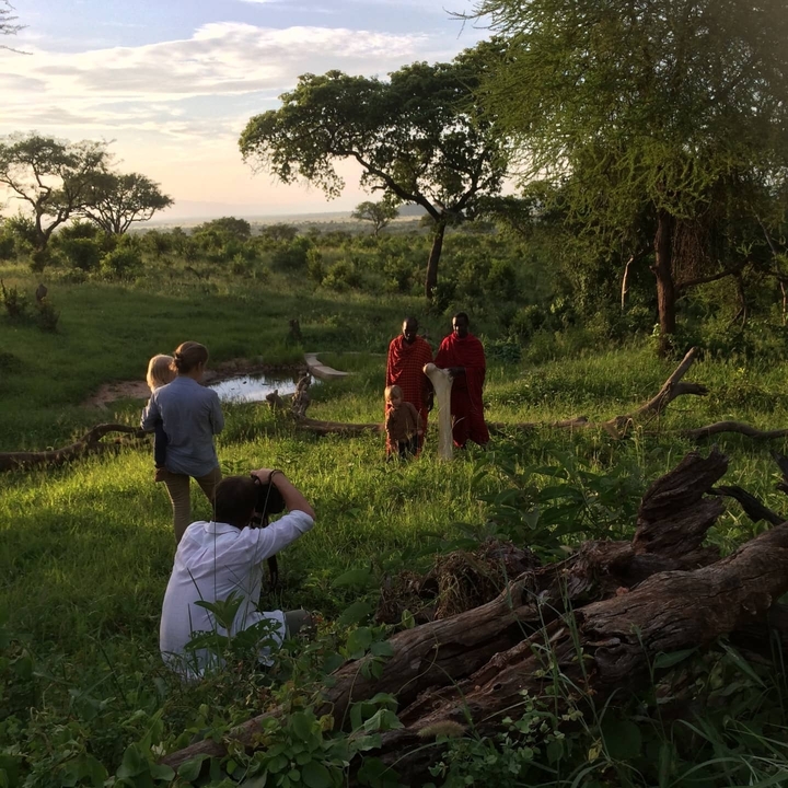 Des photographes prenant des photos de personnes Maasaï dans un paysage luxuriant.