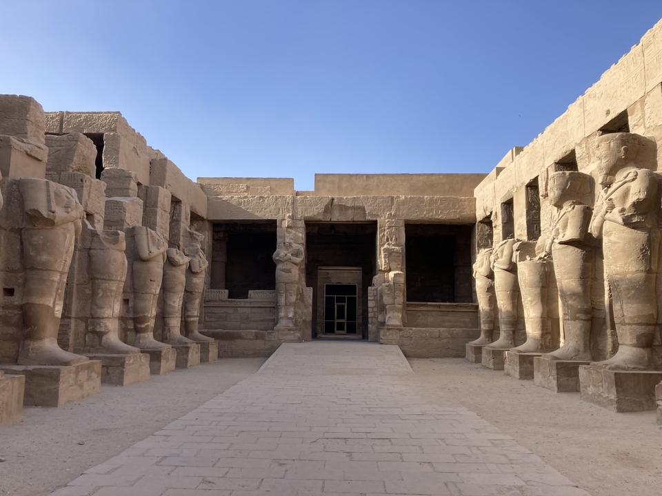 Une cour de temple antique avec de grandes statues à Louxor.