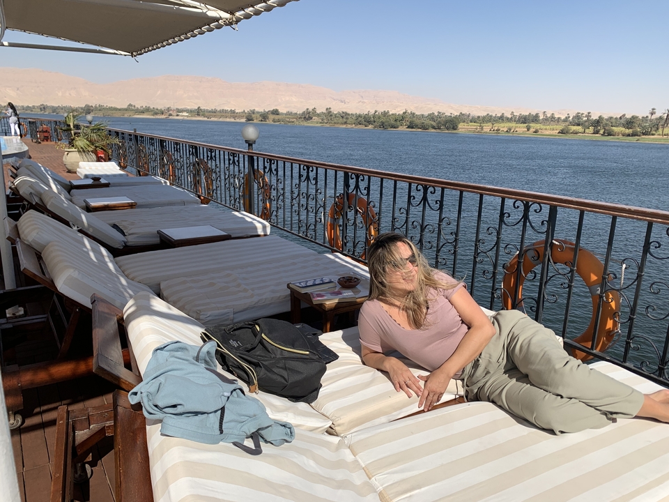 Femme se relaxant sur un bateau avec vue sur la rivière.