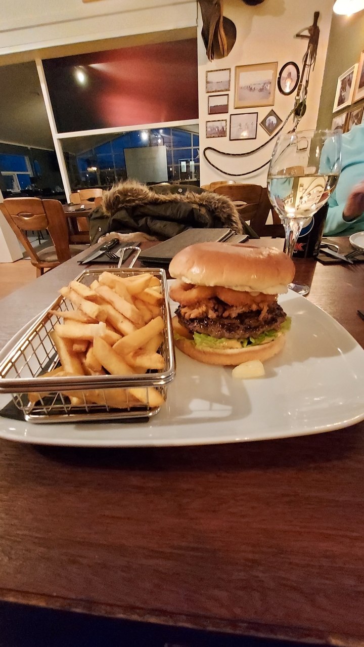 Assiette de nourriture avec un hamburger et des frites sur une table en bois.
