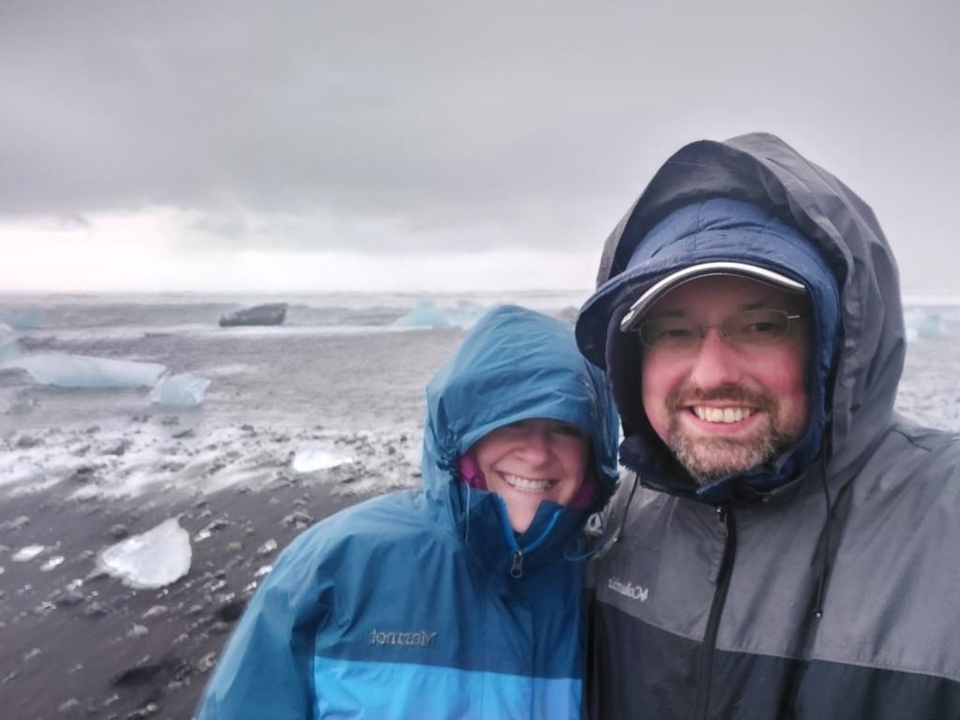 Couple portant des vestes à capuche dans un environnement enneigé.
