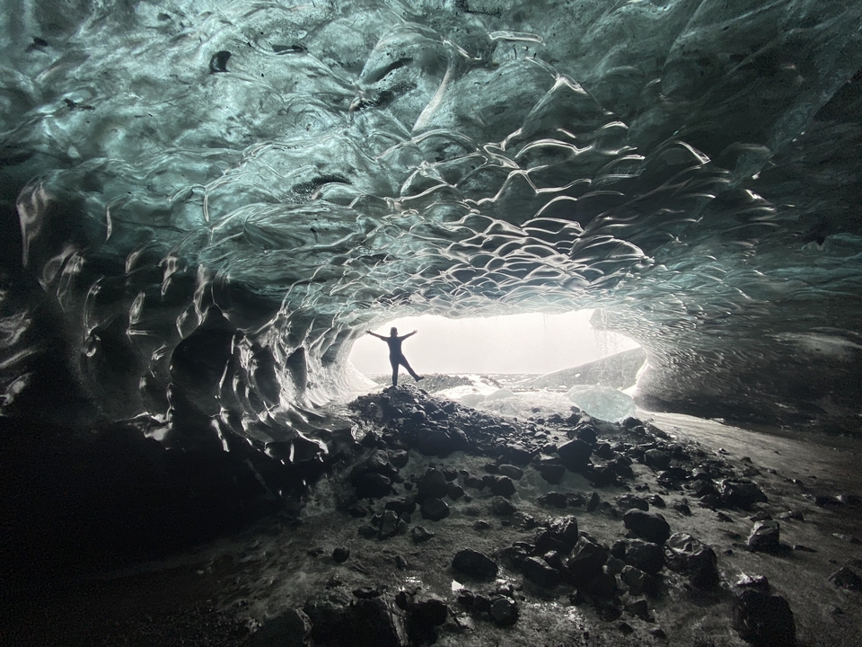 Silhouette of a person standing inside an ice cave