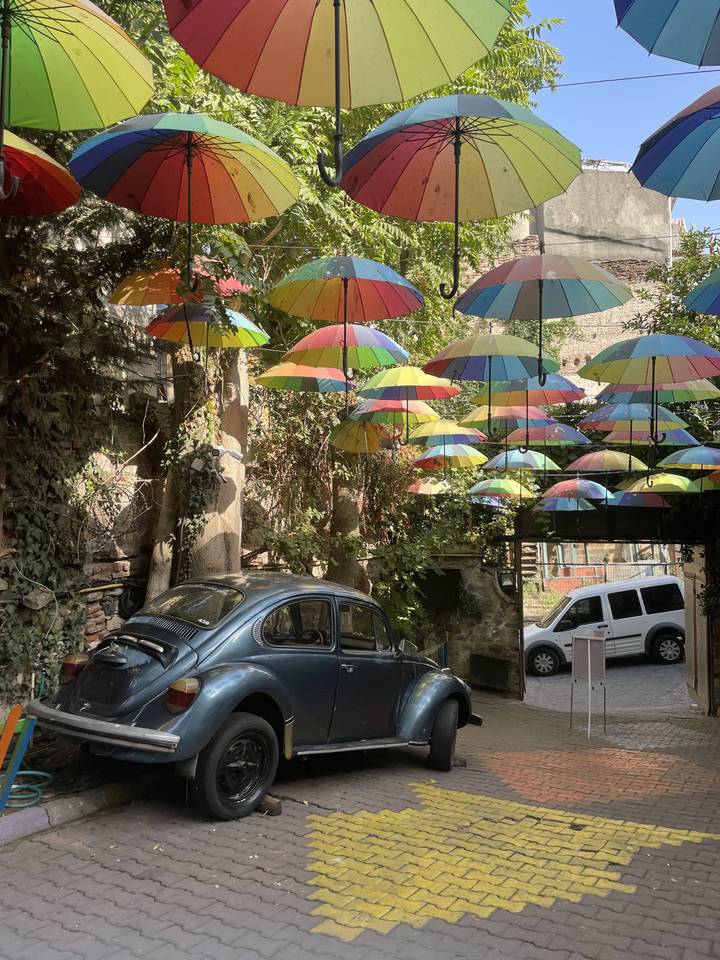 Parapluies colorés suspendus au-dessus d'une voiture garée dans la rue