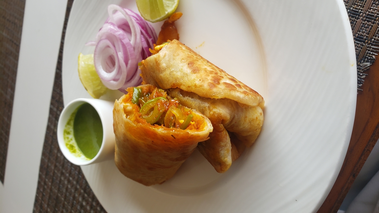 Gros plan d'une assiette avec du pain plat roulé et une trempette.