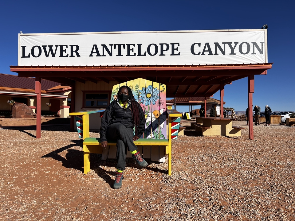 Une personne assise devant le panneau du Lower Antelope Canyon.