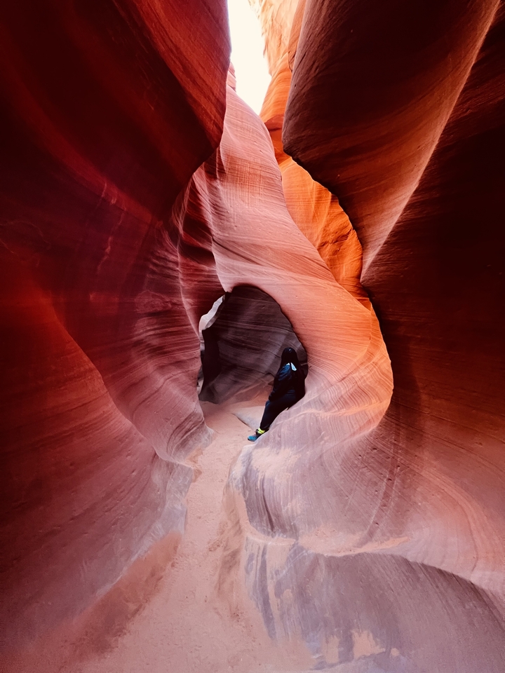 Personne debout dans un canyon étroit aux roches rouges.