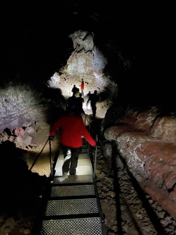 Des gens qui marchent dans une grotte sombre ou un tunnel.