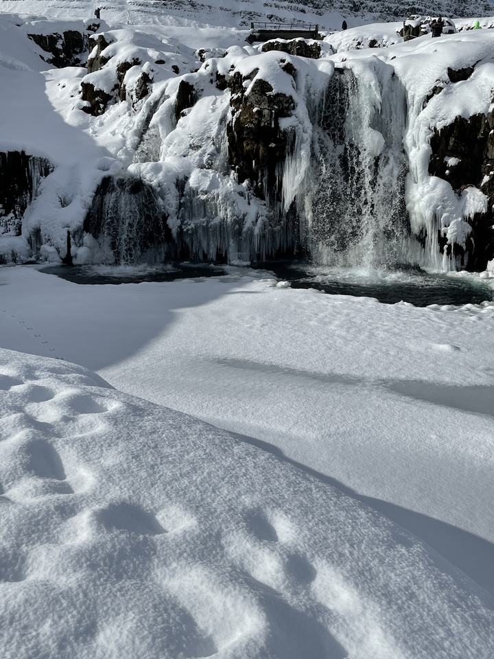 Un paysage enneigé avec une cascade gelée.