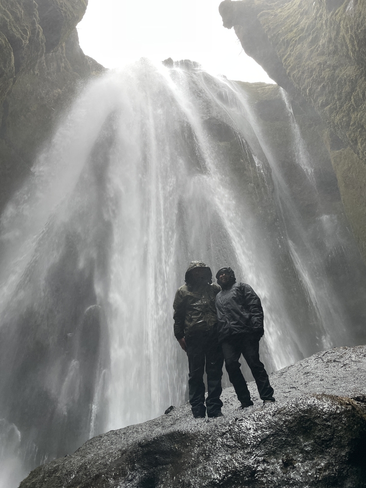 Deux personnes debout près d'une cascade.
