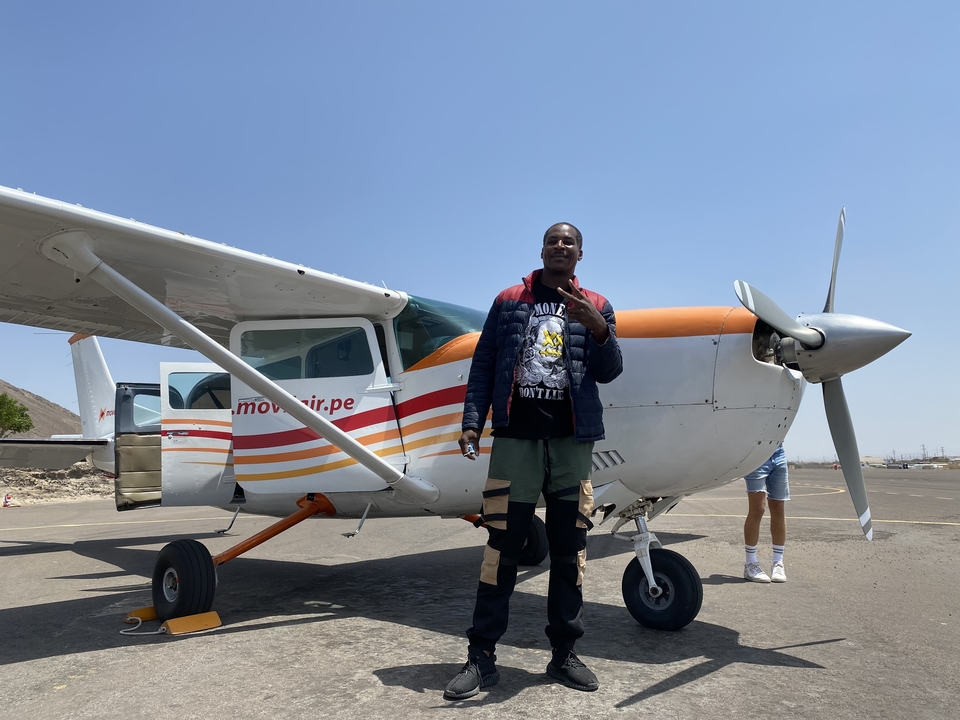 Homme debout devant un petit avion.