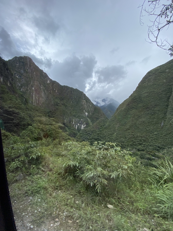 Montagnes couvertes de nuages avec une végétation luxuriante au premier plan.