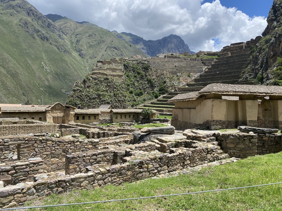 Ruines incas parmi les montagnes vertes sous un ciel dégagé.