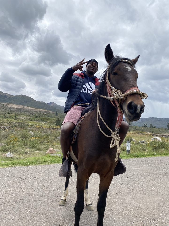 Personne à cheval posant avec les montagnes en arrière-plan.