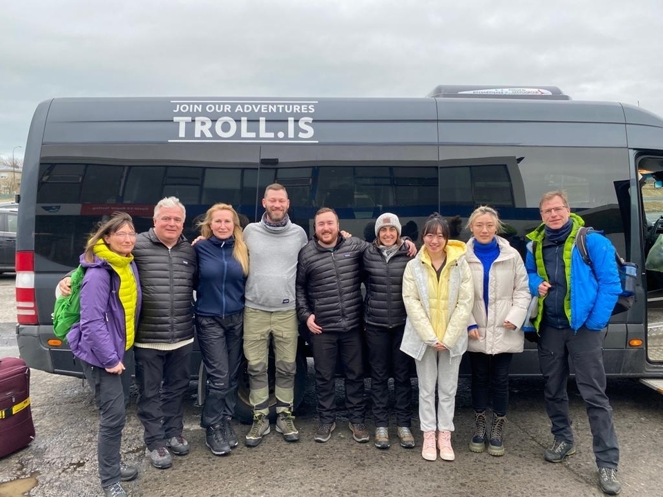 Un groupe de personnes debout devant une camionnette.