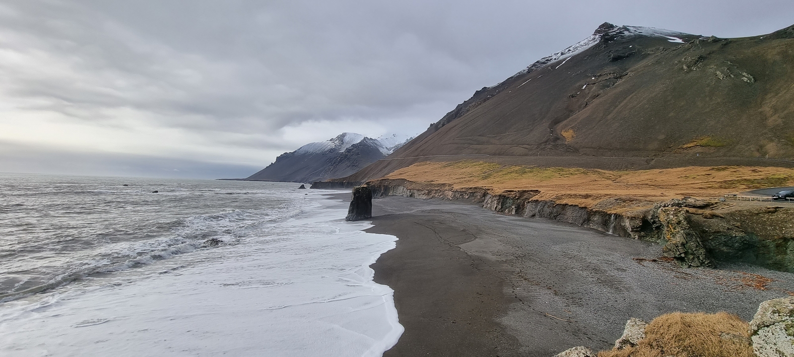Un paysage côtier avec des vagues qui rencontrent le rivage.