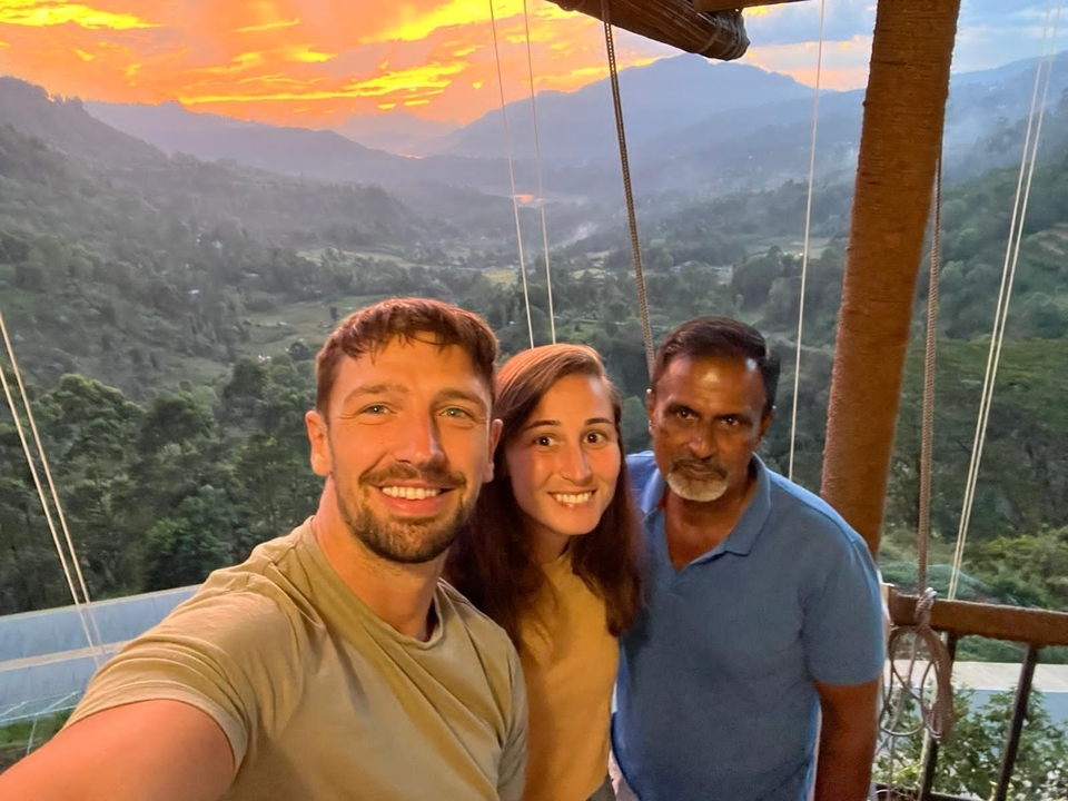 Selfie de groupe avec un paysage de montagne en arrière-plan au crépuscule.