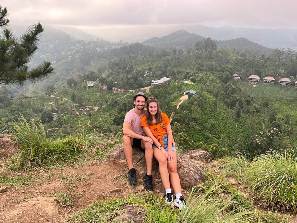 Couple assis sur un rocher avec une vue panoramique.