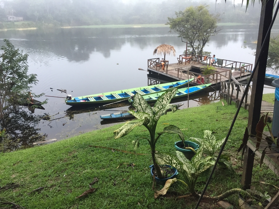 Des bateaux amarrés à une jetée en bois sur une rivière.