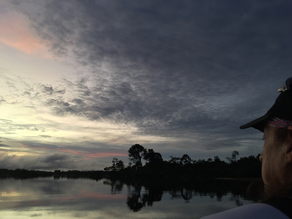 Personne admirant une rivière pittoresque au coucher du soleil.